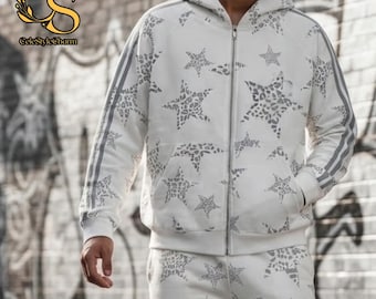 Puede incluir: Un conjunto de sudadera blanca con cremallera y pantalón a juego que presenta un patrón repetitivo de estrellas grises con textura de estampado de leopardo. La sudadera incluye capucha, cremallera frontal completa y tres rayas grises en las mangas.