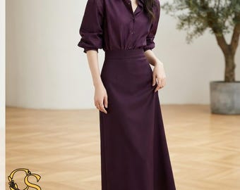 Puede incluir: Una camisa de manga larga con botones de color morado oscuro combinada con una falda midi de cintura alta a juego. La camisa presenta un cuello clásico y puños abotonados, mientras que la falda tiene una silueta recta y limpia.