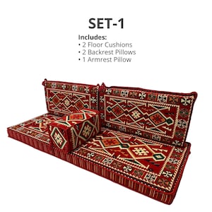 Puede incluir: Un juego de cojines de suelo, cojines de respaldo y un cojín para el reposabrazos. Los cojines y almohadas tienen un fondo rojo con un patrón geométrico en tonos marrones, verdes y blancos. El juego incluye dos cojines de suelo, dos cojines de respaldo y un cojín para el reposabrazos.