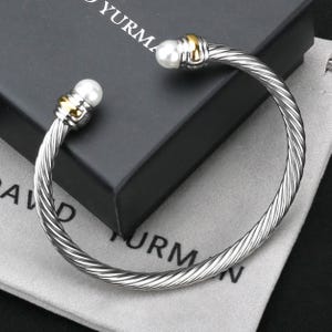 May include: A handmade wooden sign with the text "Welcome to our home" in a handwritten style. The sign is painted white with black lettering and a distressed finish, suitable for indoor or outdoor use.