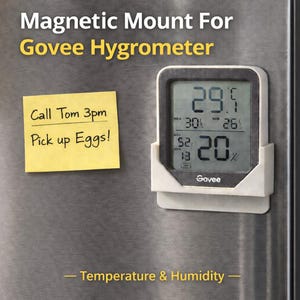 May include: A Govee hygrometer with a white magnetic mount displays temperature and humidity readings. A yellow sticky note with the text "Call Tom 3pm Pick up Eggs!" is attached to the surface. The text "Temperature & Humidity" is at the bottom.