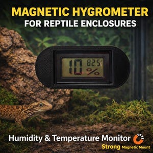 May include: A black magnetic hygrometer for reptile enclosures shows a temperature of 28.0 degrees Celsius and 10% humidity. The device is mounted on a background with a lizard and moss.