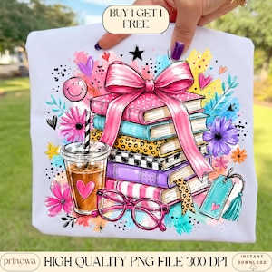 May include: A white t-shirt featuring a colorful graphic of a stack of books tied with a large pink bow, a plastic cup with a straw, and pink glasses. The design includes flowers, hearts, stars, and the text BUY 1 GET 1 FREE at the top.