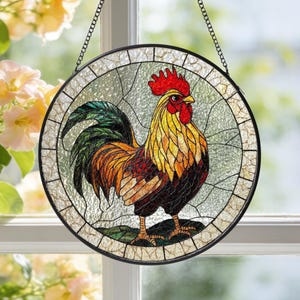 May include: A circular stained glass window hanging with a black metal frame and chain. It depicts a colourful rooster in shades of red, yellow, orange, green, and brown. The background is light green and white.