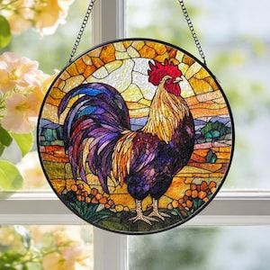 May include: A round stained glass window hanging featuring a colorful rooster. The rooster has a red comb, yellow and orange feathers, and a purple tail. The background depicts a landscape with a yellow and orange sky.