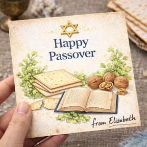 May include: A square card with the text "Happy Passover" and a Star of David. The card features illustrations of matzah, walnuts, an open book, and greenery. The words "from Elizabeth" are written at the bottom.
