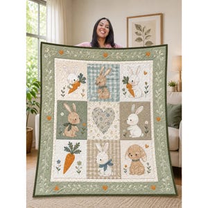 May include: A quilted blanket featuring a grid of nine squares with illustrations of rabbits, carrots, and a central heart. The border is sage green with a white vine pattern and small orange hearts. The color palette includes soft greens, browns, and white.