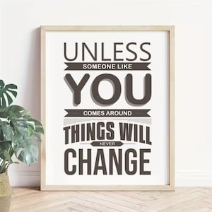 Könnte beinhalten: Gerahmter Druck mit dem Text "UNLESS SOMEONE LIKE YOU COMES AROUND THINGS WILL NEVER CHANGE" in dunkler grauer Schrift. Der Druck befindet sich in einem hellen Holzrahmen und ist vor einer weißen Wand ausgestellt.