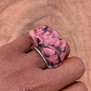 以下が含まれることがあります： 黒いハンドルと「But First, Coffee」のテキストが黒い太字で書かれた白いセラミックマグ。マグカップはニュートラルな背景に置かれ、シンプルなデザインが際立っています。