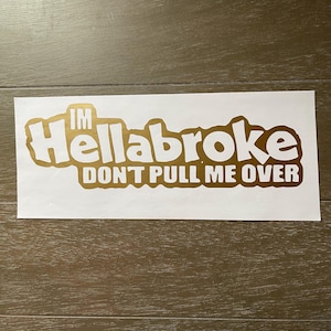 May include: A rectangular white decal featuring metallic gold lettering. The text reads "IM Hellabroke" in a large, bold, rounded font, with the words "DON'T PULL ME OVER" printed in a smaller, blocky, sans-serif font directly underneath.