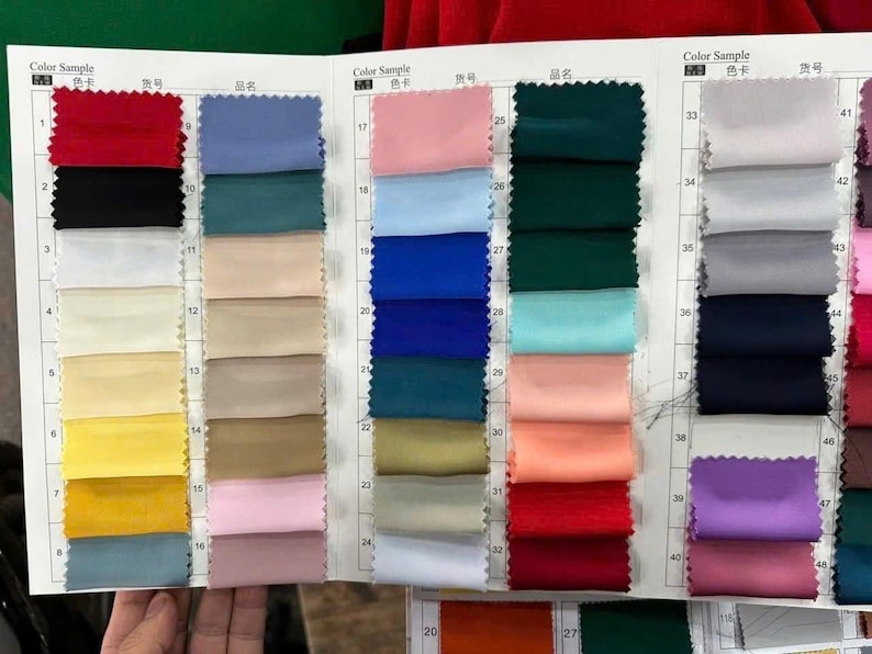 May include: A fabric colour sample chart featuring a grid of rectangular textile swatches in various colours including red, black, white, yellow, blue, green, pink, and purple, organised in numbered rows with headers labelled Color Sample.