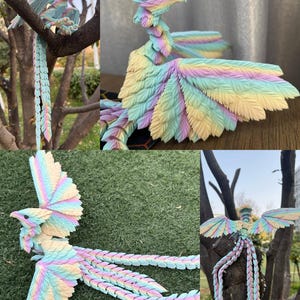 May include: A collection of colorful, articulated bird sculptures. The birds feature pastel wings, tails, and bodies in shades of blue, yellow, pink, and green. The sculptures are posed on tree branches and grass, showcasing their intricate designs.