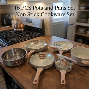 May include: A 16-piece non-stick cookware set. The set includes various pots and pans in a light gray color with wooden handles and glass lids. The cookware is arranged on a wooden countertop near a stove.