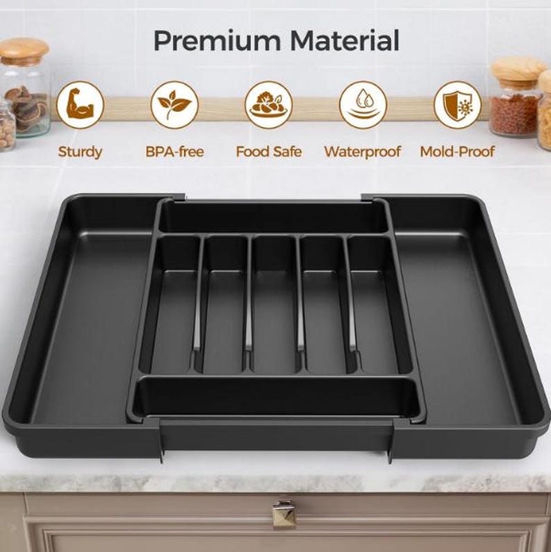 Puede incluir: Un organizador negro de utensilios de cocina con m&uacute;ltiples compartimentos. El organizador est&aacute; hecho de un material duradero y est&aacute; dise&ntilde;ado para caber dentro de un caj&oacute;n. La imagen tambi&eacute;n incluye el texto "Premium Material" e iconos para "Sturdy", "BPA-free", "Food Safe", "Waterproof" y "Mold-Proof".