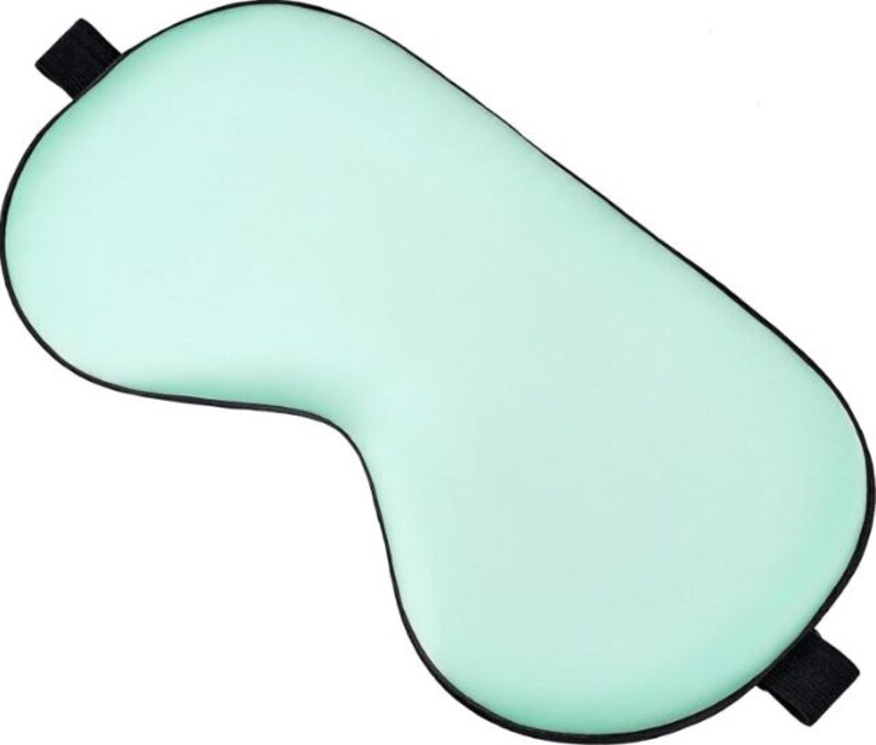 Peut inclure: Un masque de sommeil vert clair avec une bordure noire et des sangles &eacute;lastiques noires. Le masque est con&ccedil;u pour bloquer la lumi&egrave;re et favoriser la d&eacute;tente. Le masque est fait d'un mat&eacute;riau doux.