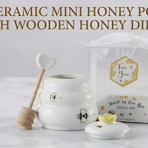 May include: A white ceramic mug with a black handle and the text "But First, Coffee" in a bold, black font. The mug is set against a blurred background, suggesting a cozy setting.