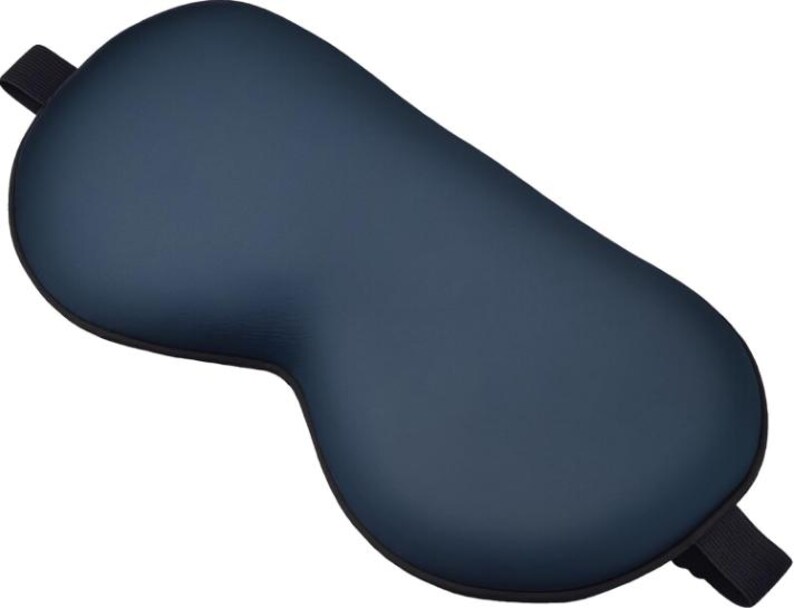Peut inclure: Un masque de sommeil bleu marine avec une forme incurv&eacute;e con&ccedil;ue pour couvrir les yeux. Le masque a une sangle &eacute;lastique noire de chaque c&ocirc;t&eacute; pour le fixer autour de la t&ecirc;te. Le masque est fait d'un mat&eacute;riau lisse.