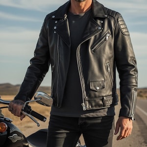 May include: Black leather motorcycle jacket with a classic asymmetrical zip closure, quilted shoulder detailing, and multiple zippered pockets. The jacket features a notched lapel collar and silver-toned hardware. The model is wearing a gray t-shirt and black jeans.