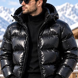 Pode incluir: Um casaco acolchoado preto brilhante com capuz, apresentando canais acolchoados horizontais, um fecho de correr frontal completo e punhos canelados. O casaco é usado sobre uma camisola preta de gola alta, com calças pretas e óculos de sol.