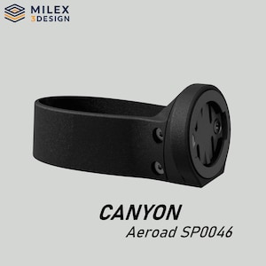 May include: A black bicycle computer mount for a Canyon Aeroad SP0046. The mount is made of a durable material and features a circular mounting point and a band to secure it to the handlebars. The Milex 3 Design logo is in the top left corner.