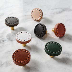 May include: A set of three ceramic mugs with a speckled, matte finish. The mugs are in shades of cream, light gray, and dark gray. Each mug has a simple, minimalist design, perfect for coffee or tea.