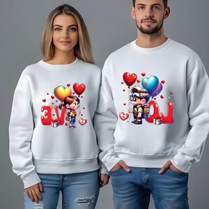 May include: White sweatshirts with matching cartoon graphics. One sweatshirt features a girl holding heart-shaped balloons next to the word "LOVE". The other sweatshirt has a boy with balloons next to the word "LOVE". Both sweatshirts have red heart accents.