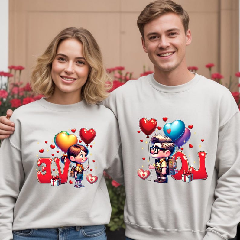 May include: Matching light gray sweatshirts with a cartoon design featuring a boy and girl holding heart-shaped balloons. The word "LOVE" is spelled out in red letters. A gift box is also included in the design.