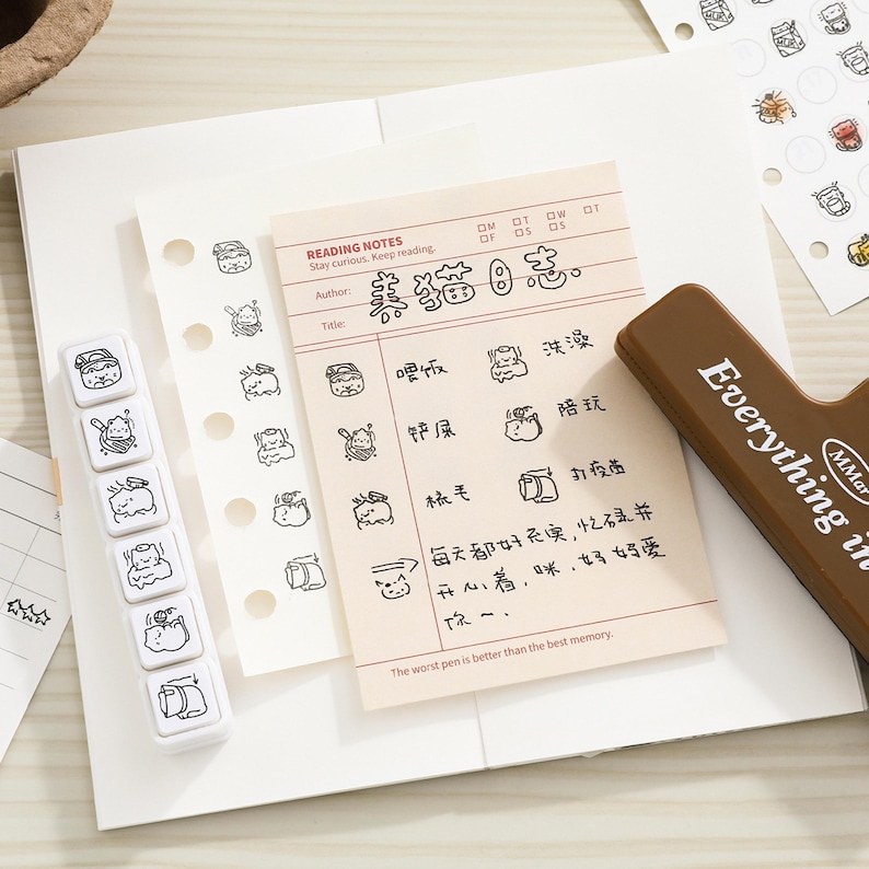 May include: A cream-colored reading notes paper sheet with black cat illustrations and Chinese text, a white vertical stamp block with six cat icons, and a brown rectangular stamp handle with the text Everything is MMar.