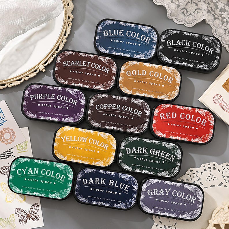 May include: A collection of rectangular ink pads in various colors, including blue, black, scarlet, gold, purple, copper, yellow, red, dark green, cyan, dark blue, and gray. Each pad is labeled with its color name and "color space".