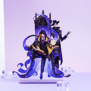 May include: Acrylic stand featuring two anime-style figures. One figure sits on a throne, wearing a black and gold robe, while the other stands beside them in a black coat and hat. The throne and figures have a blue and purple color scheme.