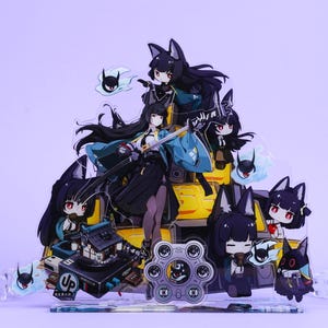 Puede incluir: Una pantalla acrílica multicapa con personajes de estilo anime con cabello negro y orejas de zorro. Los personajes están ambientados sobre un fondo amarillo y negro, con una variedad de accesorios y un fondo morado claro.