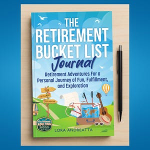 May include: A hardback book titled "The Retirement Bucket List Journal" with a blue and white cover. The cover features illustrations of travel-related items, including a bicycle, guitar, and map. A black pen rests beside the book.