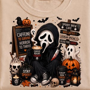 May include: A beige t-shirt featuring a graphic of a hooded figure with a white mask holding a coffee mug and a knife. The design includes a chalkboard with the text CAFFEINE TO SURVIVE HORROR TO THRIVE, a sign for SPOOKY BREW CAFE, pumpkins, a ghost, and skulls.