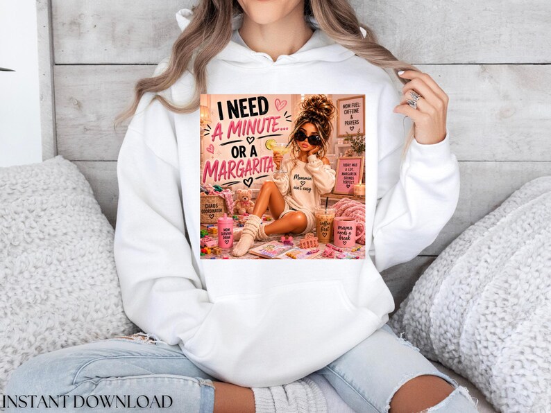 May include: A white hooded sweatshirt featuring a graphic print of a person with sunglasses holding a drink, surrounded by text that reads I NEED A MINUTE OR A MARGARITA, along with various pink and brown accessories and small decorative items.