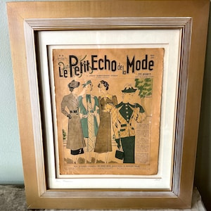 May include: A framed vintage magazine cover titled Le Petit Echo de la Mode, featuring four illustrations of individuals in 1930s-style coats and dresses. The print is set within a wide, textured gold frame with a white mat and glass covering.