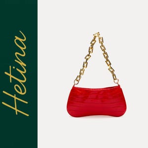May include: A bright red handbag with a textured surface and a thick gold-toned chunky chain strap. The bag features a curved, elongated shape. To the left, the word Hetina is written in a gold cursive script against a dark green background.