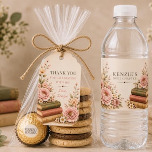 May include: A clear plastic bag containing a stack of round biscuits and a gold-wrapped Ferrero Rocher chocolate, tied with twine and a tag reading Thank You For Celebrating With Me! Love, Kenzie, alongside a water bottle labelled Kenzie's Next Chapter.