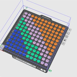 May include: A black rectangular plate covered in a grid of smiley faces in various colours: blue, green, purple, and orange. The plate has the text "Bambu Smooth PEI High Temp Plate". The smiley faces are arranged in rows and columns.