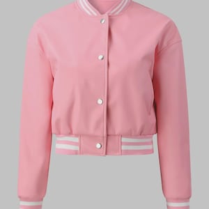 May include: A pink bomber jacket with a ribbed hem and cuffs. The jacket has a white and light pink striped collar, cuffs, and hem. It features a button-up front with silver buttons. The jacket is a solid pink color.