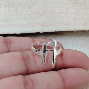 Op de afbeelding: Een zilveren ring met een minimalistisch ontwerp. De ring heeft twee verticale staven, één aan elke kant van de vinger, verbonden door een band. De ring zit op een hand en de tekst "garimagemshop" is zichtbaar.