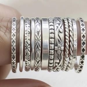 May include: A set of three ceramic mugs with a speckled, matte finish. The mugs are in shades of cream, light gray, and dark gray. Each mug has a simple, minimalist design, perfect for coffee or tea.