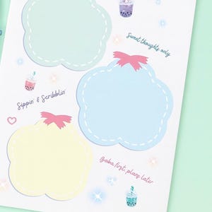 May include: A white paper sheet with three cloud-shaped notepads in pastel colors: light green, blue, and yellow. Each notepad has a pink bow at the top. The text "I ♡ Boba", "Sweet thoughts only", "Sippin' & Scribblin'", and "Boba first, plans later" are also visible.