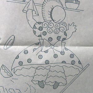 May include: A black and white line drawing of a girl in a polka dot dress holding a broom. She is wearing a hat and has a bow on her dress. The drawing is on a light brown background. The text "GP8" is in the bottom right corner.