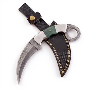 May include: A curved karambit knife with a Damascus steel blade and a green handle. The knife is in a black leather sheath with gold stitching and a black leather strap with a brass button.