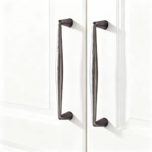 May include: Two dark gray cabinet pulls with a textured finish are mounted on a white cabinet door. The pulls have a curved design and are approximately 12 inches in length, adding a touch of elegance to the cabinetry.