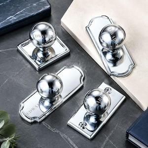 May include: Four polished chrome door knobs with spherical handles and rectangular or arched backplates. Each knob features the word EDWARDS engraved on the surface. The hardware includes visible mounting screws on the rectangular plates.