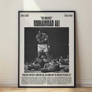 Puede incluir: Póster enmarcado en blanco y negro con Muhammad Ali de pie sobre su oponente en un combate de boxeo. El texto "THE GREATEST" y "MUHAMMAD ALI" están en la parte superior. La cita "FLOAT LIKE A BUTTERFLY, STING LIKE A BEE. HIS HANDS CAN'T HIT WHAT HIS EYES CAN'T SEE" está en la parte inferior.