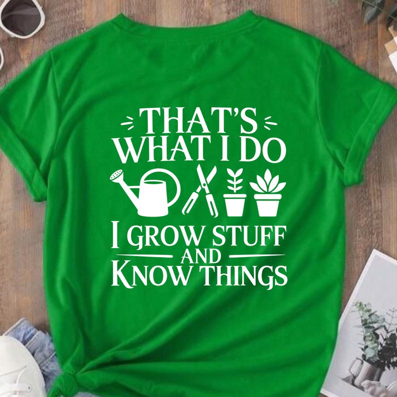 Puede incluir: Una camiseta de manga corta de color verde brillante con texto serigrafiado en blanco que dice THAT'S WHAT I DO I GROW STUFF AND KNOW THINGS. El dise&ntilde;o incluye iconos gr&aacute;ficos blancos de una regadera, tijeras de podar y dos plantas.