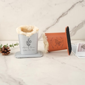 May include: Two personalized pen holders. One is silver with a floral design and the names "Alexis & Brian" and the date "October 17th, 2025". The other is brown with the same details. Both have a soft, fluffy interior.
