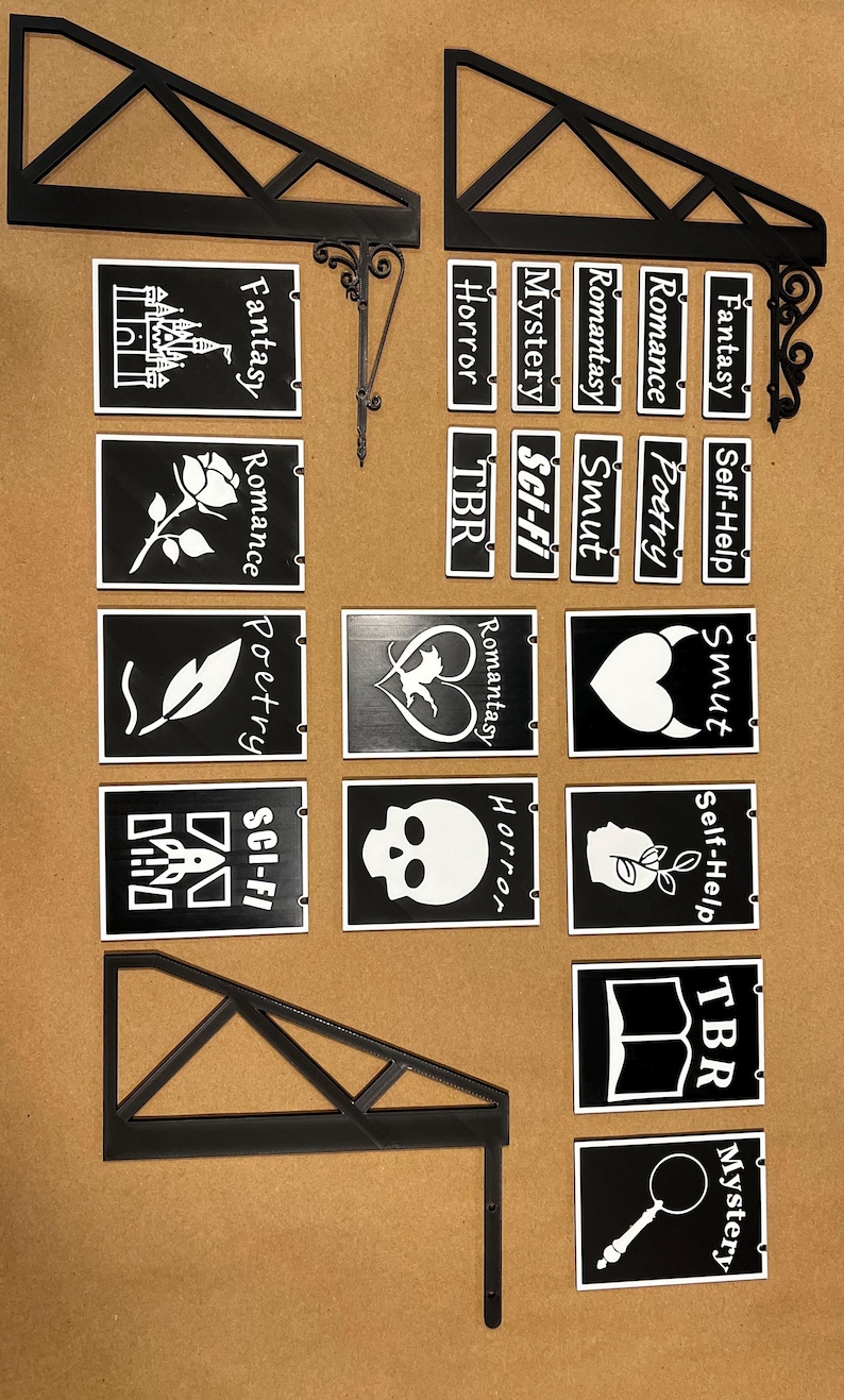 May include: Black and white signs with various genre labels, including "Fantasy," "Romance," "Horror," and "Sci-Fi." The signs are designed to hang from a decorative bracket, perfect for a bookstore or library.